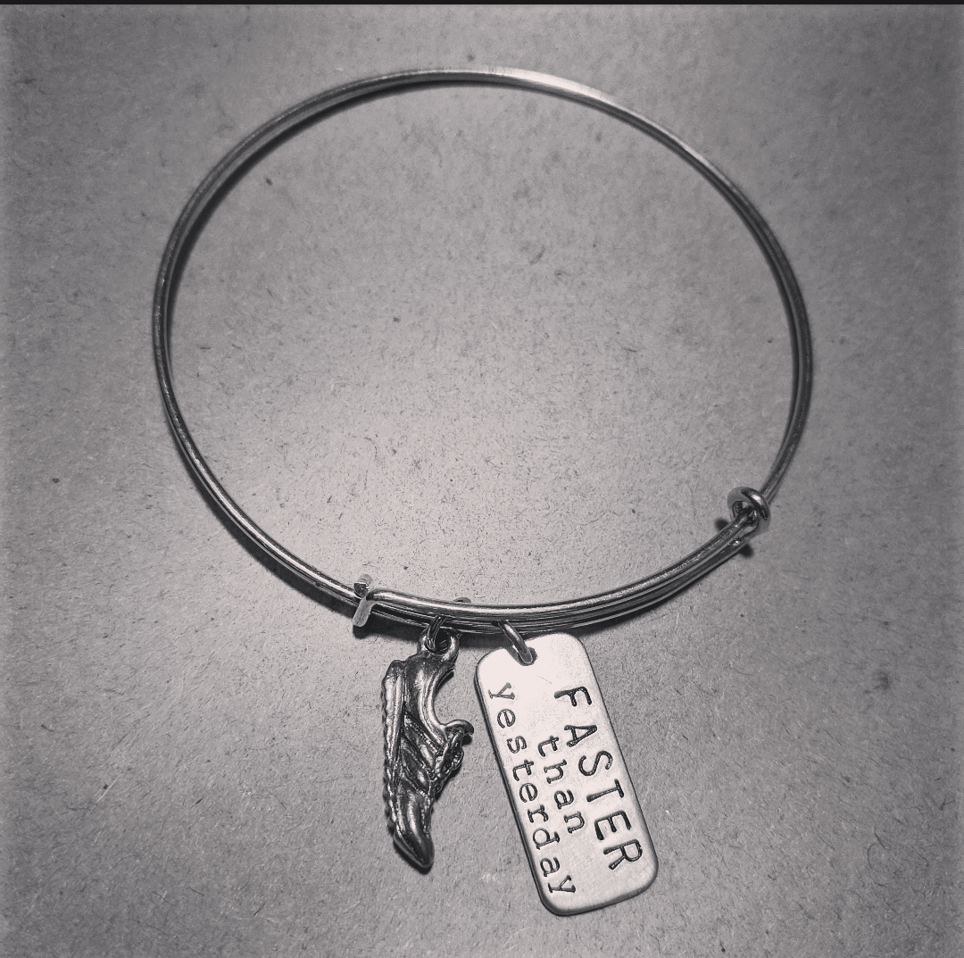 Stainless Steel bracelet with a running shoel charm and a charm that says faster than yesterday