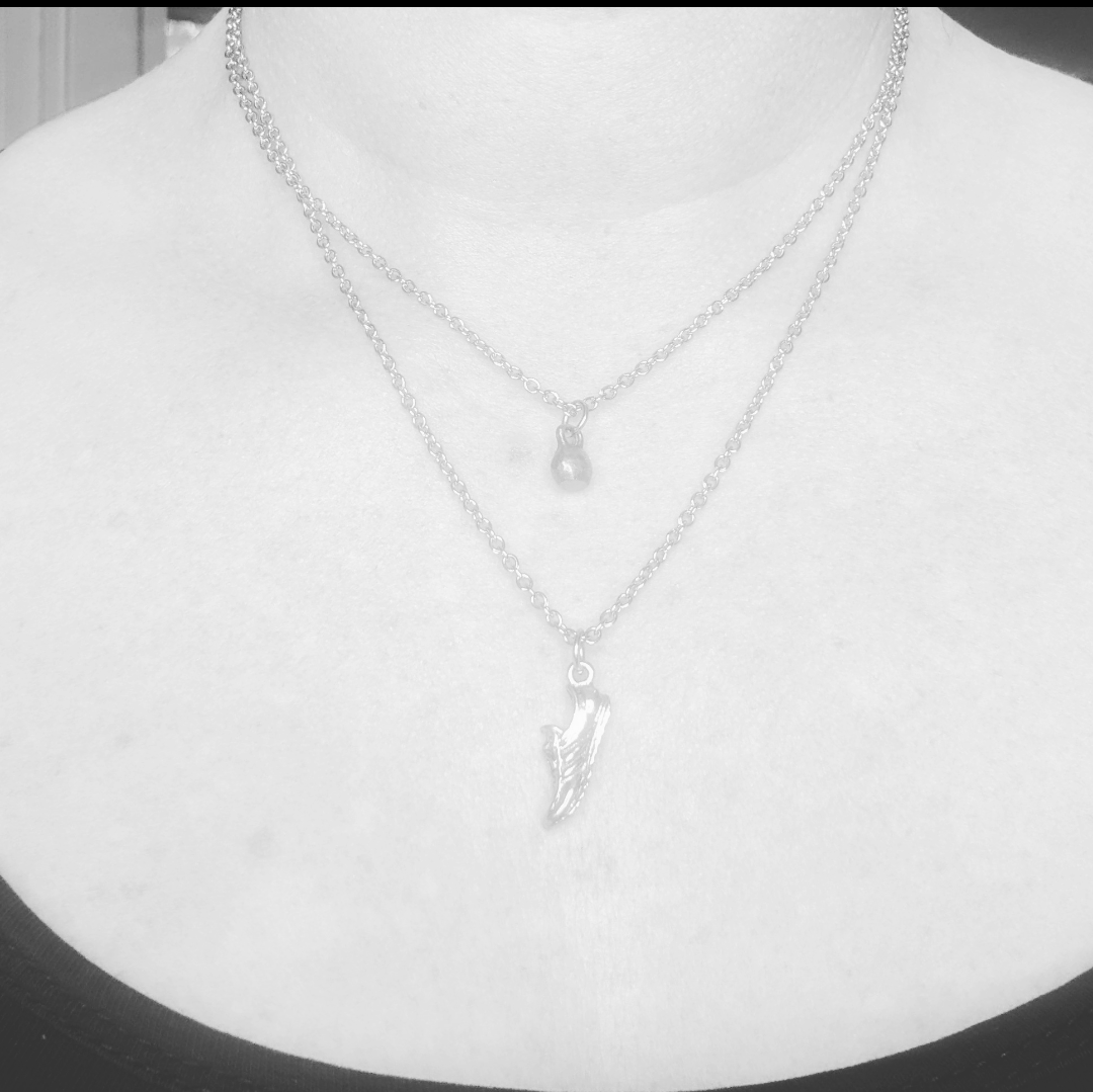 one shorter necklace with a mini kettle bell charm and one longer necklace with a running shoe charm