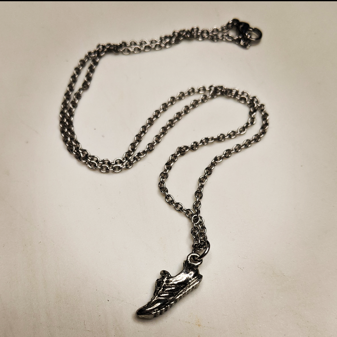 a necklace with a running shoe charm