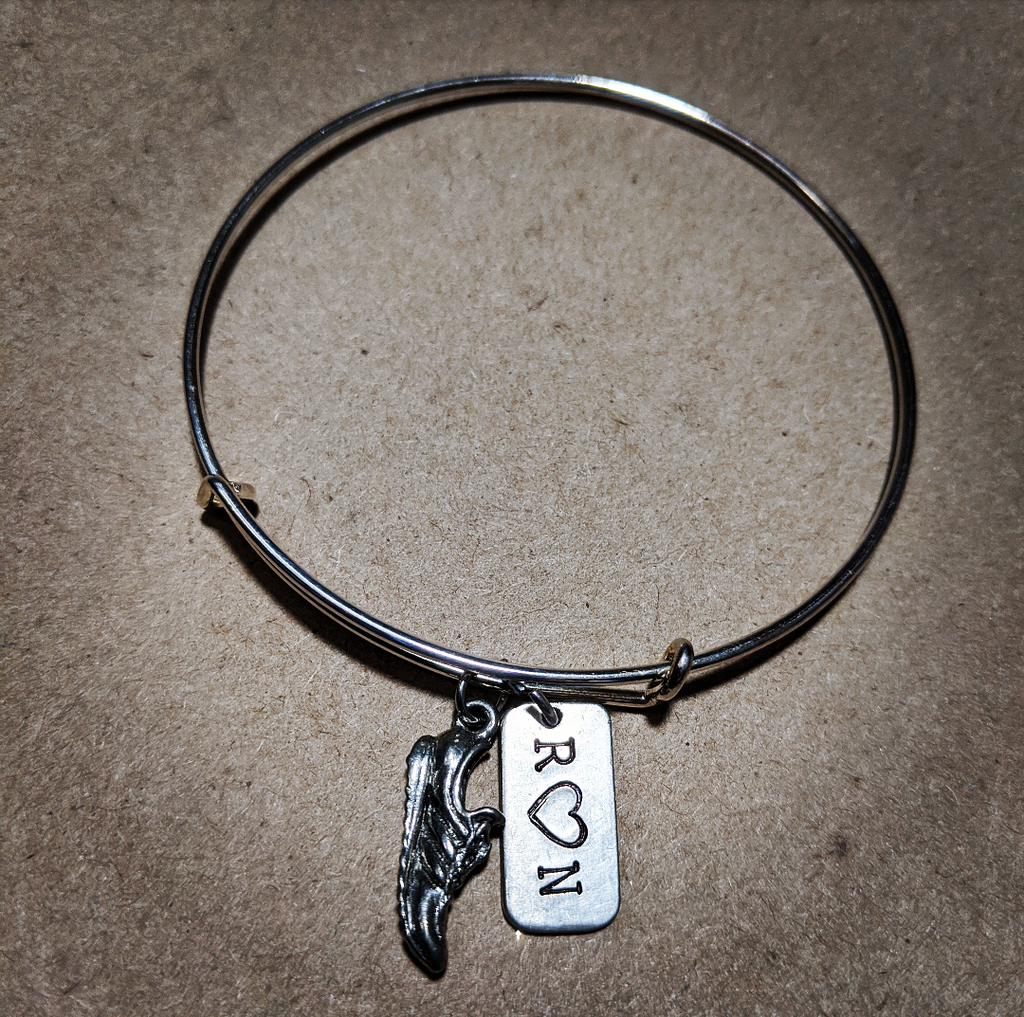 Stainless Steel bracelet with a running shoe charm and a charm that says R heart N on it
