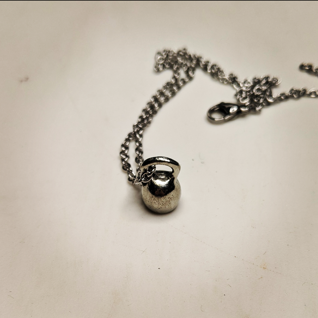 a necklace with a mini kettle bell charm 