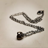 Necklace with a mini kettle bell charm on it