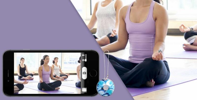Girl in a yoga class taking a photo from a distance using the Clickie Self Remote technology tool that allows you to take remote photos. 